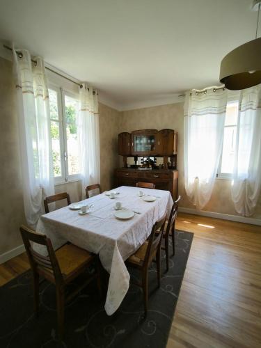 une salle à manger avec une table et des chaises blanches dans l'établissement Appartement 6 pers, 3 chambres, au 1er étage, d'une maison à Luz Saint Sauveur, Hautes-Pyrénées, à Luz-Saint-Sauveur