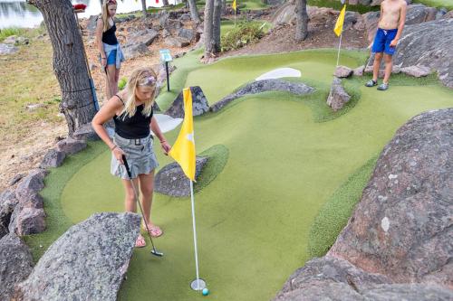a woman is standing on a miniature golf course at First Camp Gunnarsö-Oskarshamn in Oskarshamn