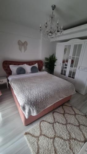 a bedroom with a large bed and a chandelier at Lux apartament in Focşani