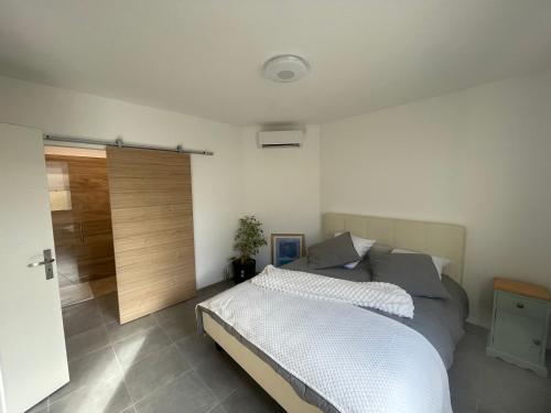 - une chambre avec un lit et une porte coulissante dans l'établissement l'Esquirou, à Malemort-du-Comtat