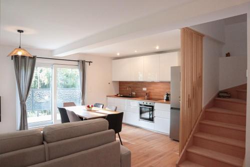 Il comprend un salon et une cuisine avec une table et un canapé. dans l'établissement Duplex Harmonie proche frontière, à Huningue