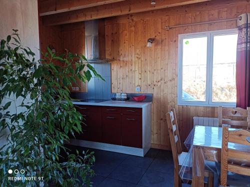 - une cuisine avec une table et une fenêtre dans une chambre dans l'établissement Chalet Chez Picou, à La Tour-dʼAuvergne
