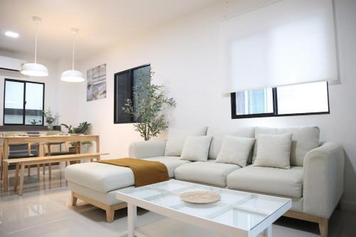 a living room with a couch and a table at Cozy Homey Place Townhome in Bangkok