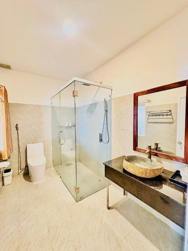 a bathroom with a sink and a shower and a toilet at Paradise Resort Doc Let - All Inclusive in Doc Let