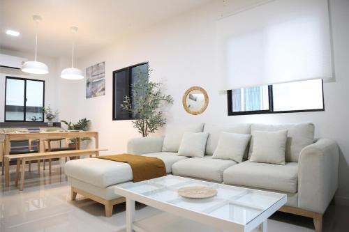 a living room with a couch and a table at Cozy Homey Place Townhome in Bangkok