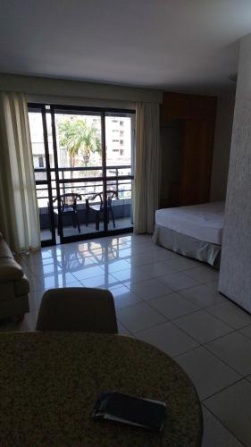 a hotel room with a bed and a view of a balcony at REDE APARTHOTEL Praia Mansa in Fortaleza