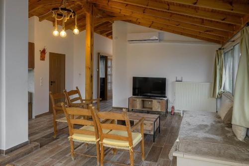 a living room with a table and a tv at Aphrodite Apartment Near The Beach and The Airport in Áyios Spirídhon