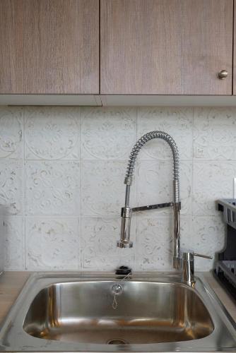 a kitchen sink with a faucet in a kitchen at Aphrodite Apartment Near The Beach and The Airport in Áyios Spirídhon