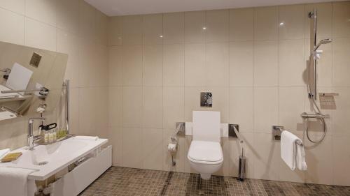 a bathroom with a toilet and a sink and a shower at Hilton Munich City in Munich