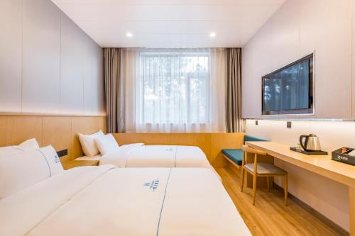 a hotel room with two beds and a desk at Dequan Luxury Hotel Communication University of China Branch Coffee, fruits, snacks, a gym and a laundry room are provided for free in the lobby in Beijing