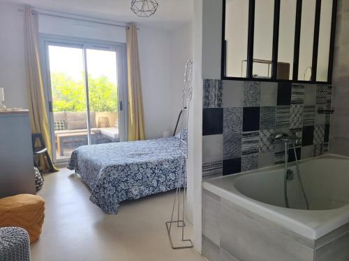 une salle de bains avec un lit et une baignoire ainsi qu'une chambre dans l'établissement Le Rambot - appartement de charme avec grande terrasse parking centre ville - proche Bellegarde, à Aix-en-Provence