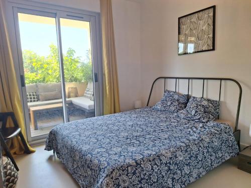 une chambre avec un lit et une porte coulissante en verre dans l'établissement Le Rambot - appartement de charme avec grande terrasse parking centre ville - proche Bellegarde, à Aix-en-Provence