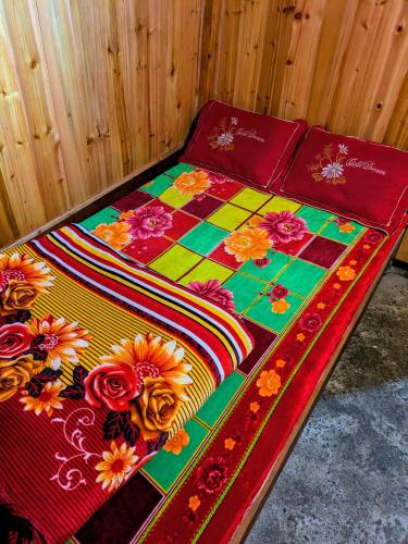 a bed with a colorful blanket and flowers on it at Homestay & Trekking Sapa Tom Tom in Sa Pả