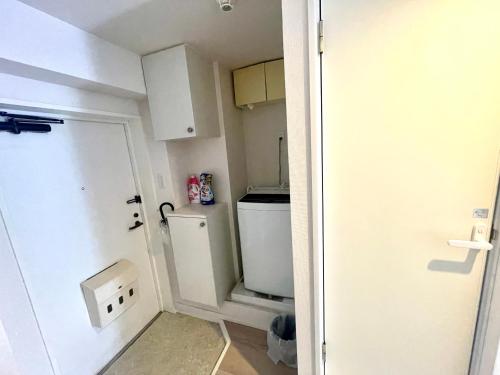 a small bathroom with a toilet and a door at West Shinjuku Entire House with 2beds in Tokyo