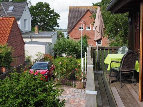 a patio with a table and an umbrella at Ferienwohnung mit Balkon und Schleiblick in Maasholm