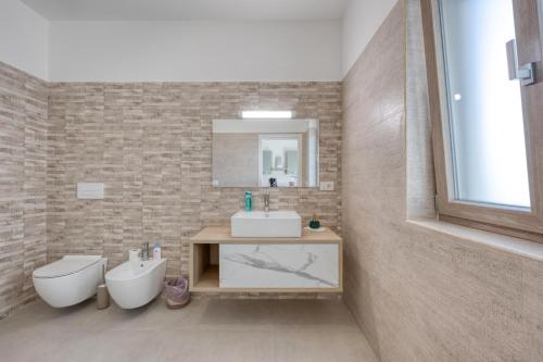 a bathroom with a sink and a toilet and a mirror at Stanza doppia vicino ospedale di Tricase - Palazzo Credaro in Tutino