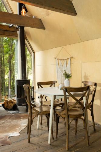 a dining room with a table and chairs and a fireplace at Hotel Kouty - Lesní Apartmány in Ledeč nad Sázavou