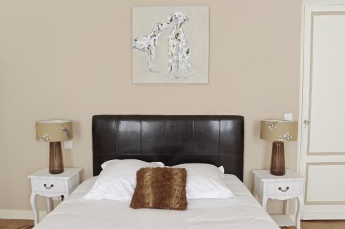 une chambre avec un lit avec une tête de lit noire et deux lampes dans l'établissement Louis Combes - Localisation exceptionnelle 1 chambre parking, à Bordeaux