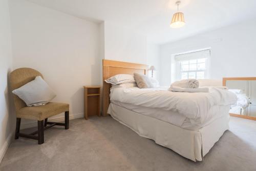 a bedroom with a large bed and a chair at Two Trees, By Birch Stays in Hetton