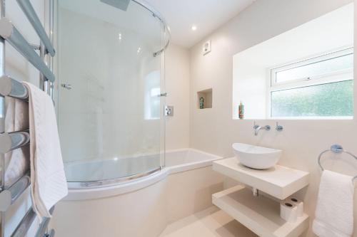 a white bathroom with a sink and a shower at Two Trees, By Birch Stays in Hetton