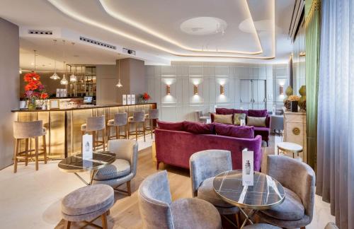 a living room with a couch and tables and chairs at Barceló Emperatriz in Madrid
