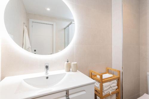 Un baño blanco con lavabo y espejo. en Holiday Apartment Ida by Solaga Holiday Homes, en Rincón de la Victoria