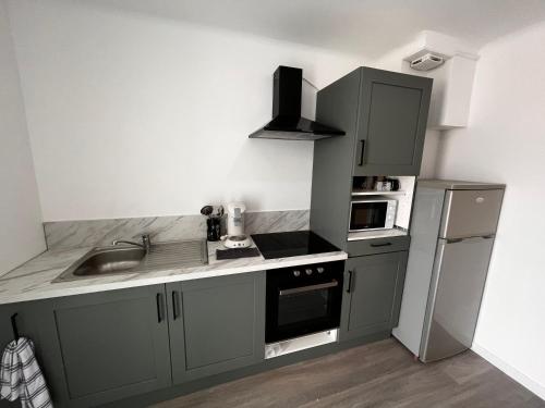 une cuisine avec un évier et une cuisinière four supérieur dans l'établissement T3 proche centre ville climatisé, à Istres