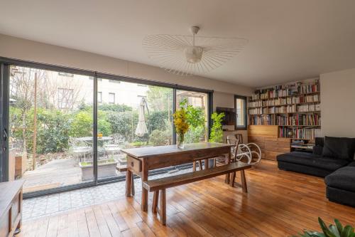 un salon avec une table et une grande fenêtre dans l'établissement Veeve - Wooden Warmth, à Paris