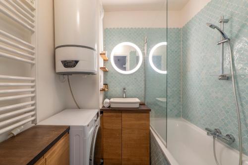 une salle de bain avec un lavabo et une douche dans l'établissement Veeve - Wooden Warmth, à Paris