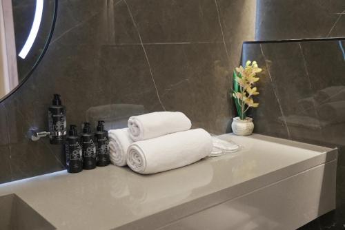 a pile of towels sitting on a counter in a bathroom at Voyage Itlalat Resort منتجع وشاليهات فوياج اطلالات in Al ‘Uyaynah