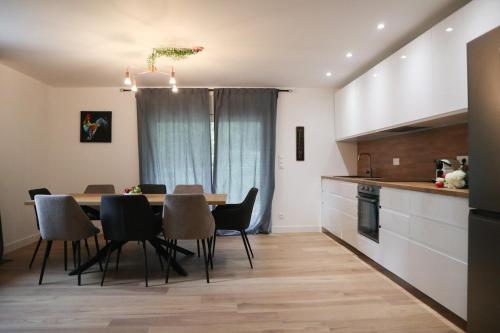 a kitchen and dining room with a table and chairs at Plaisir partagé Apartment in Huningue