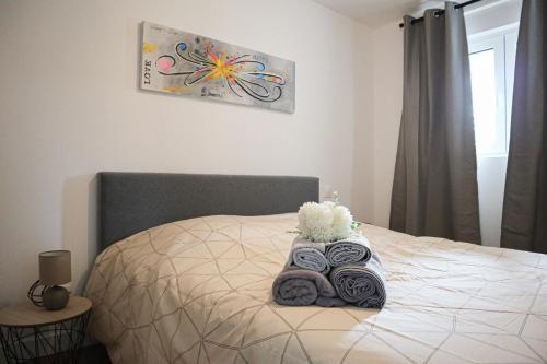 a bed with towels and a teddy bear on it at Plaisir partagé Apartment in Huningue