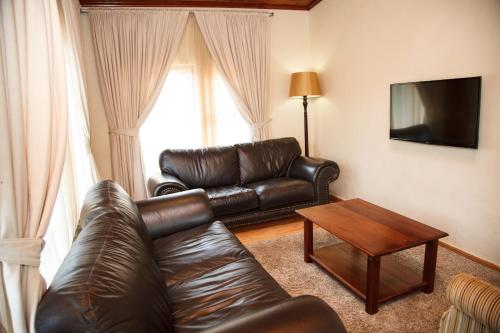 a living room with a leather couch and a coffee table at Blyde Canyon, A Forever Resort in Matibidi
