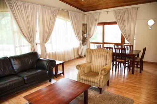 a living room with a couch and a table and chairs at Blyde Canyon, A Forever Resort in Matibidi