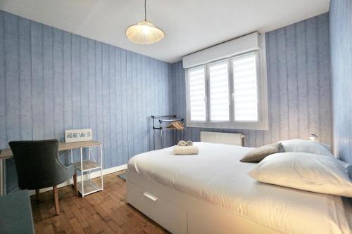 une chambre avec un grand lit blanc et un bureau dans l'établissement Urbana - centre ville - jardin, à Lorient