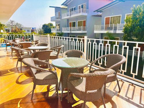 a group of tables and chairs on a balcony at The Jungle Woods Resort, Jim Corbett - A Boutique Hidden Gem in Rāmnagar