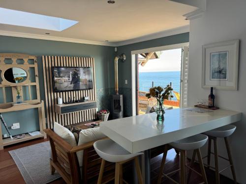 a living room with a table and a view of the ocean at Grace at C in Herolds Bay