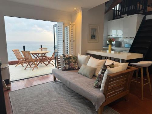 a living room with a couch and a view of the ocean at Grace at C in Herolds Bay