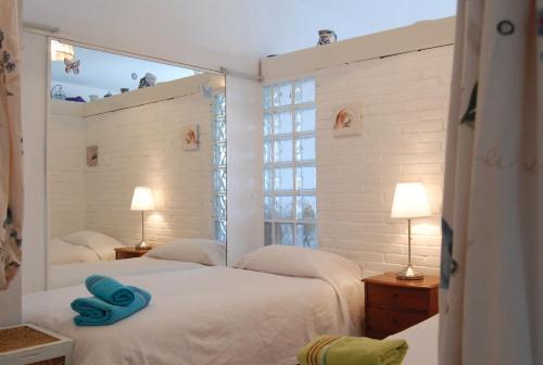 ネルハにあるCarabeo 15 Studios Casasolのベッドルーム1室(青いタオル付きのベッド2台付)