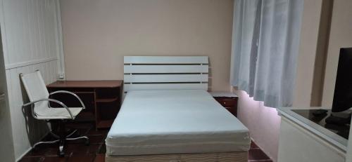 a small room with a bed and a desk and a chair at Pousada Vino & Leta O seu parador no centro in Grão Pará