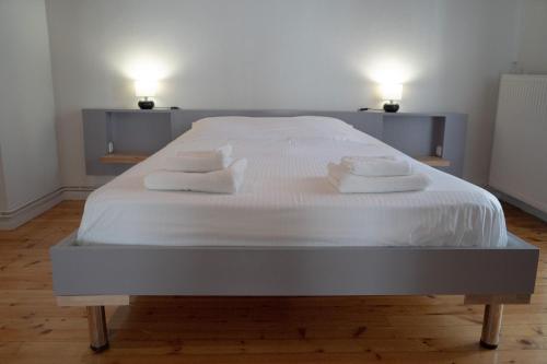 a bed with white sheets and pillows on it at Casanova94 Guesthouse in Piraeus