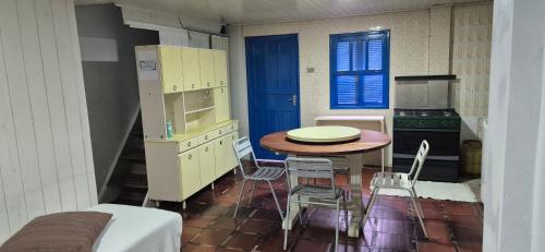 a kitchen with a table and a table and chairs at Pousada Vino & Leta O seu parador no centro in Grão Pará