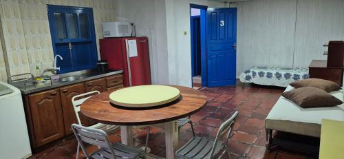 a kitchen with a table and a red refrigerator at Pousada Vino & Leta O seu parador no centro in Grão Pará