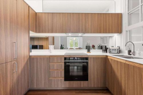a kitchen with wooden cabinets and a sink at Urban Retreat Near Sydney Harbour in Sydney