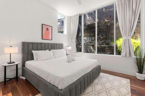 a bedroom with a large bed and a large window at Urban Retreat Near Sydney Harbour in Sydney