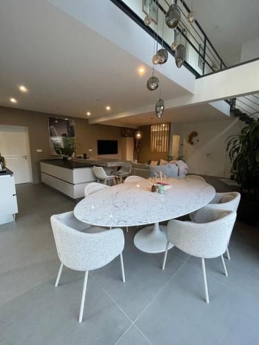 un salon avec une table et des chaises dans l'établissement A HOSSEGOR, Jolie maison avec SPA pour sejour bien être, à Soorts-Hossegor