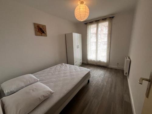 une chambre avec un lit et une grande fenêtre dans l'établissement T3 proche centre ville climatisé, à Istres