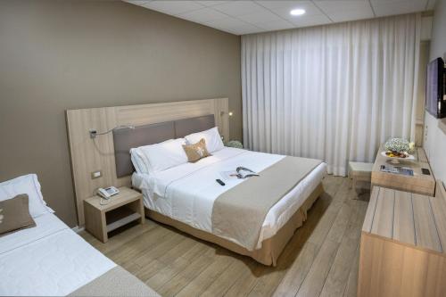 a hotel room with two beds and a television at Hotel I Gigli in Nola