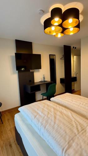 a hotel room with two beds and a chandelier at Gasthaus Adler in Dietingen