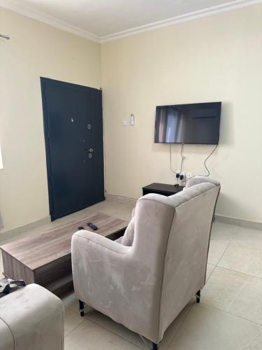 a living room with a chair and a tv at AMS Global in Accra